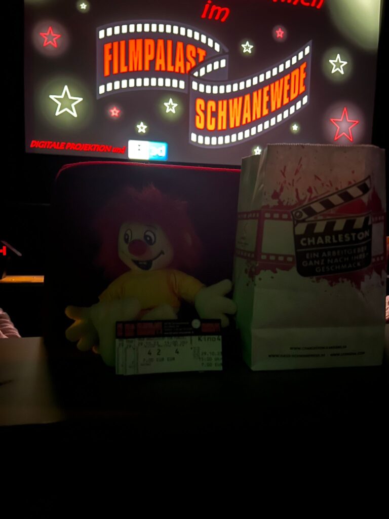 Pumuckl Figur mit Kinokarten und Popkorn im Kino