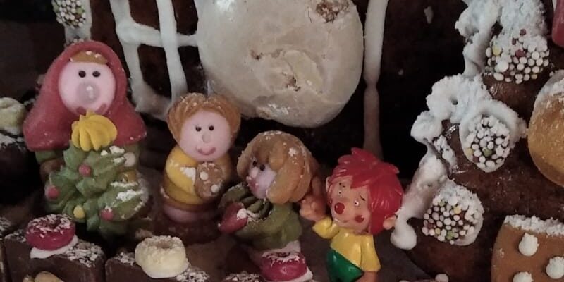 Lebkuchenhaus mit kleinen Figuren, unter anderem einem Pumuckl